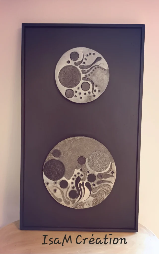 Tableau avec plaques en grès blanc, dessinées et patinées avec oxydes noires, et brossées. les plaques sont collées sur une toile en lin et encadrement en bois noir.