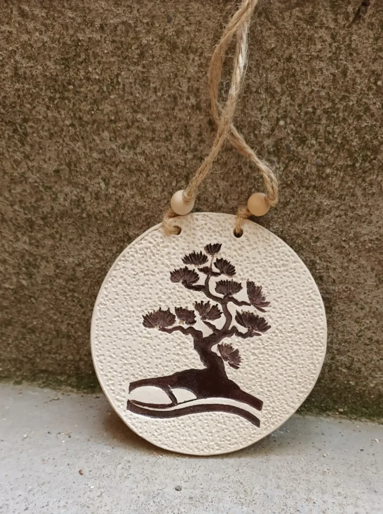Diffuseur d'huiles essentielle et de parfums, motif arbre, bonzaï marron, fond en relief, en grès blanc, perles en bois céramique, diamètre 10 cm, Isabelle Morales