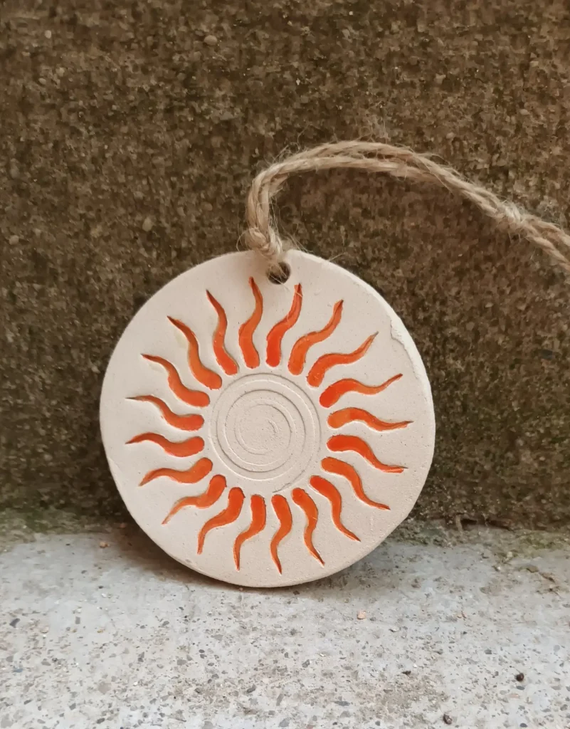 Diffuseur d'huiles essentielle et de parfums, motif soleil, spirale orange, en grès blanc, céramique, diamètre 8 cm, Isabelle Morales
