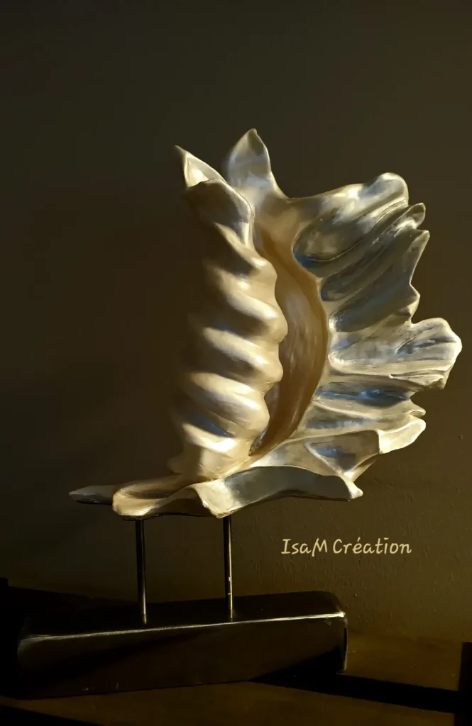 Sculpture d'un coquillage en grès blanc, patiné, sur socle en fer.