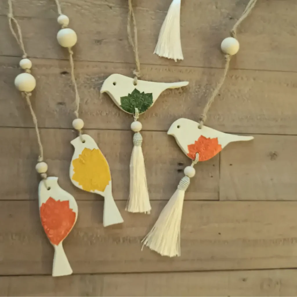 Suspension en grès blanc, oiseaux avec pompons et perles, Isabelle Morales